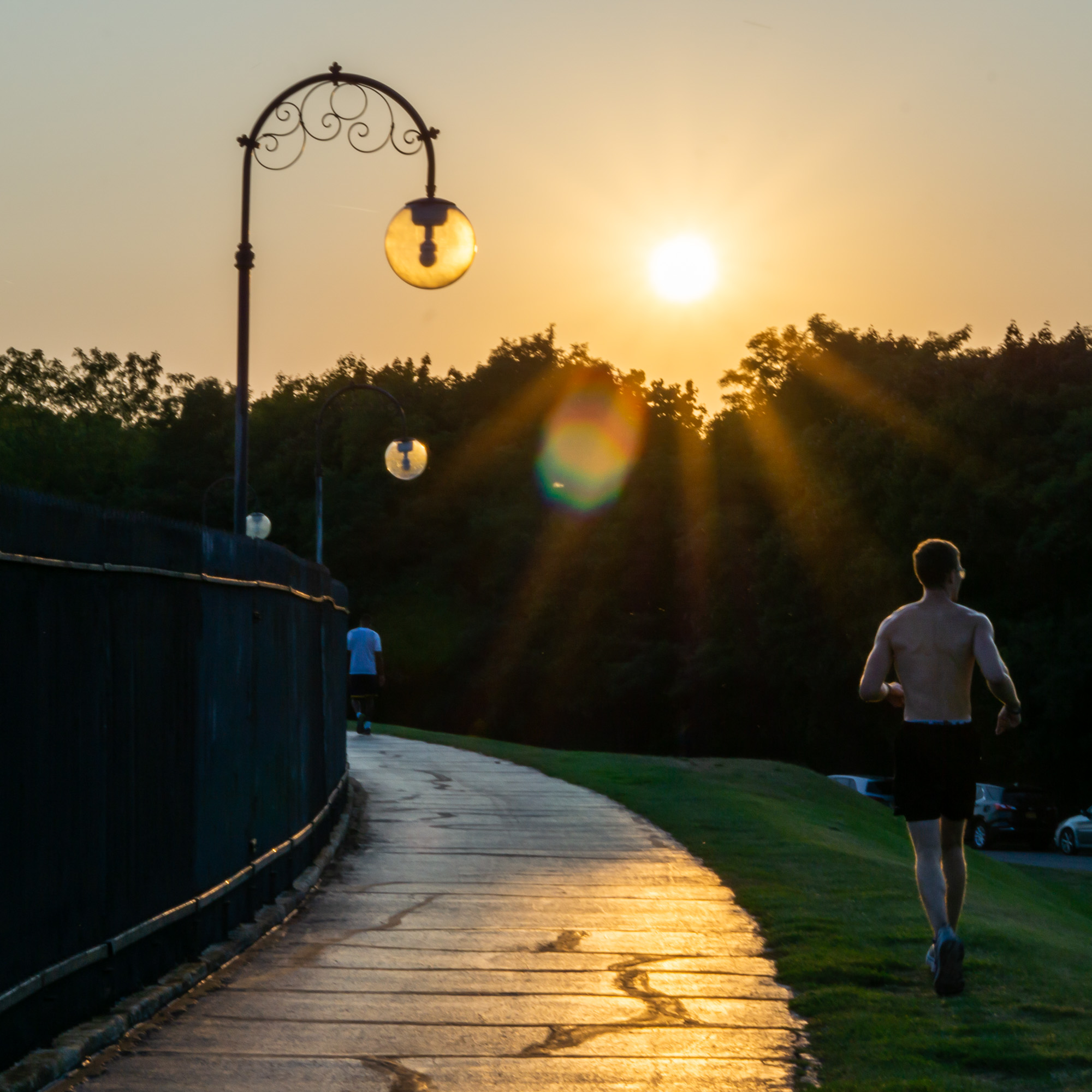 Person running at park with sunset in background