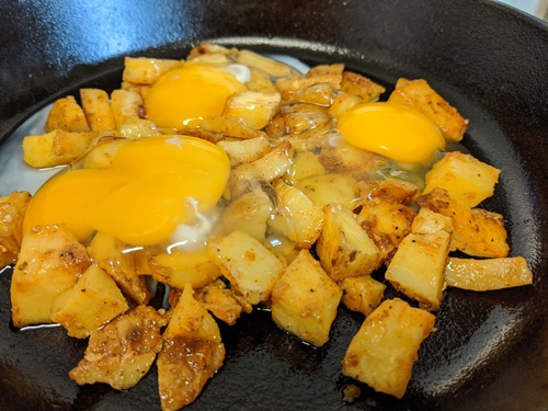 home fries cooking in eggs